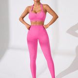 Conjunto deportivo de mujer en color rosa con sosten de cuello halter, banda de cintura fruncida y pantalon largo para yoga y fitness