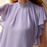 Blusa con cuello alto simulado, dees de pedreria y mangas con volantes