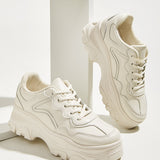 Zapatillas de deporte minimalistas con cordones en la parte delantera, par de zapatillas deportivas blancas solidas