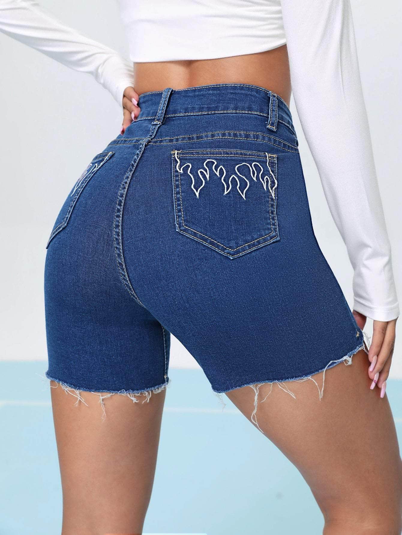 Shorts jean bajo crudo con bordado de fuego